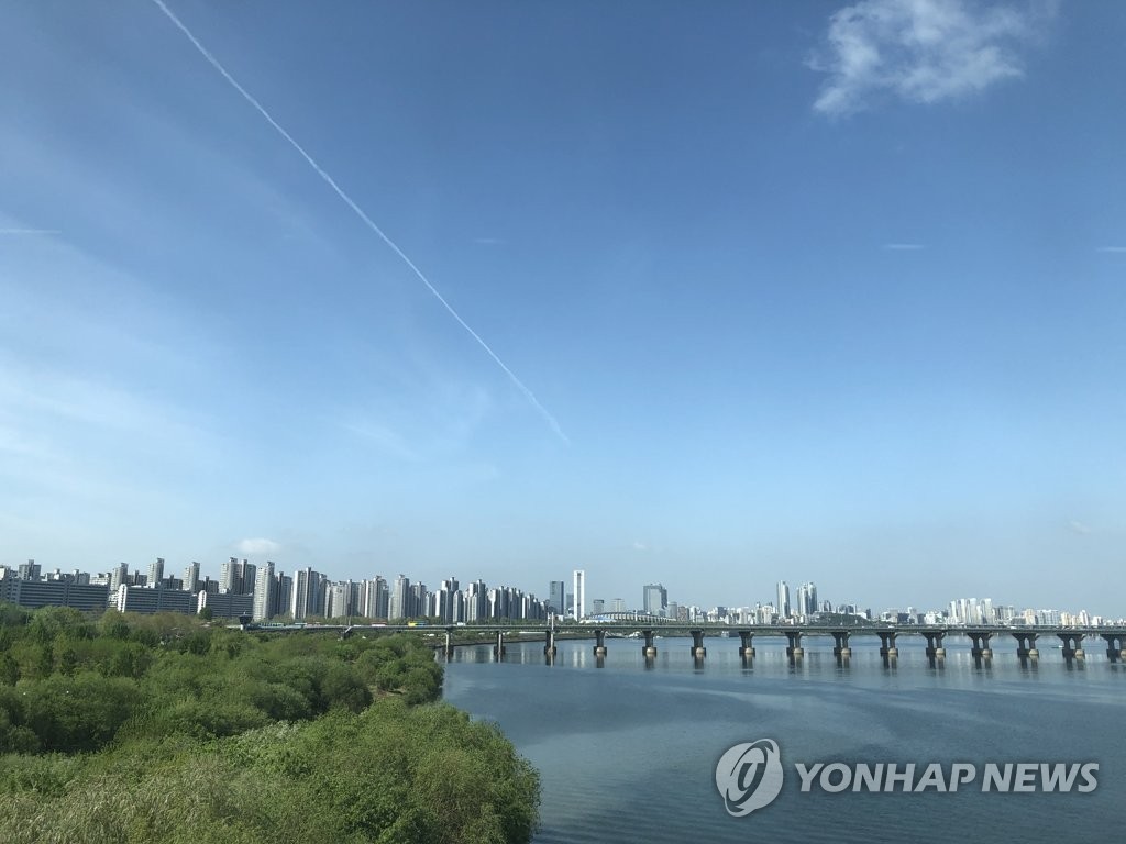 资料图片：4月26日，从首尔市蚕室洞眺望市区上空，晴朗少云。 韩联社