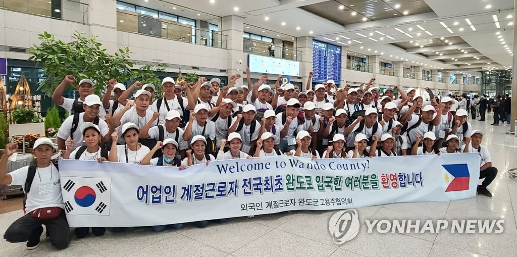 资料图片：2022年4月28日，在仁川国际机场，来自菲律宾的外籍劳工抵韩后合影留念。 韩联社/读者供图（图片严禁转载复制）