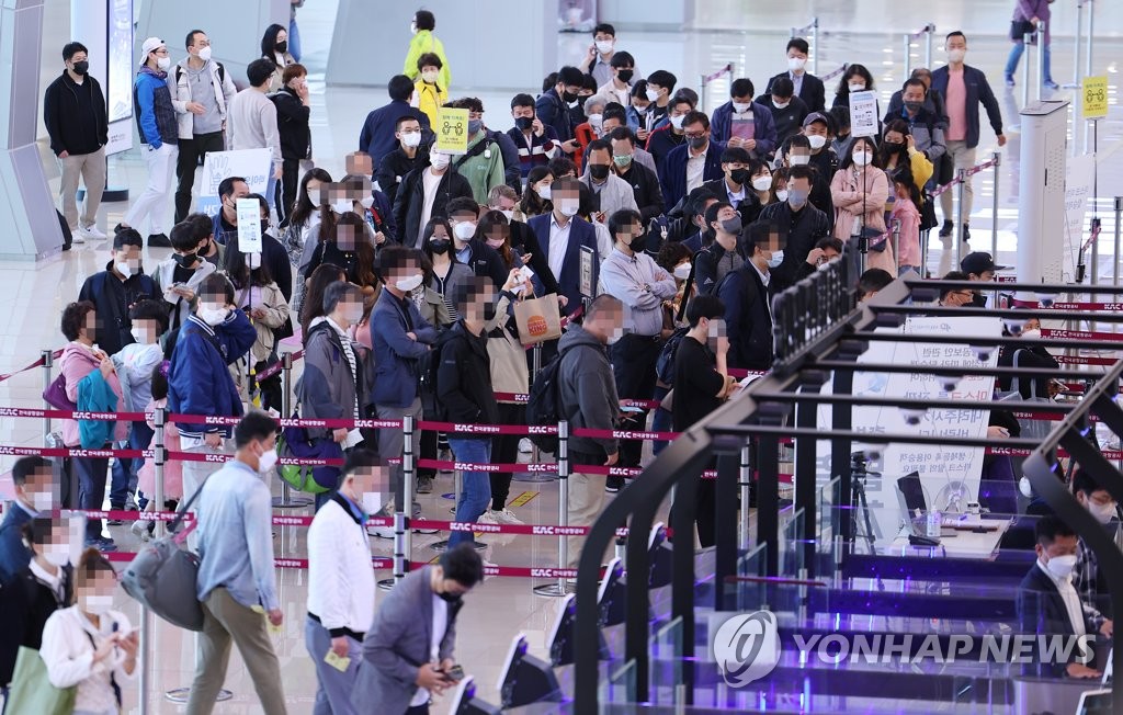 资料图片：4月29日，在首尔金浦机场，国内线出发大厅挤满旅客。韩国政府当天宣布下月2日起将解除户外戴口罩义务。 韩联社