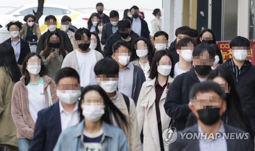 资料图片：5月2日，在首尔汝矣岛地铁站附近，市民基本都戴着口罩出行。韩国当天起解除户外佩戴口罩义务。 韩联社
