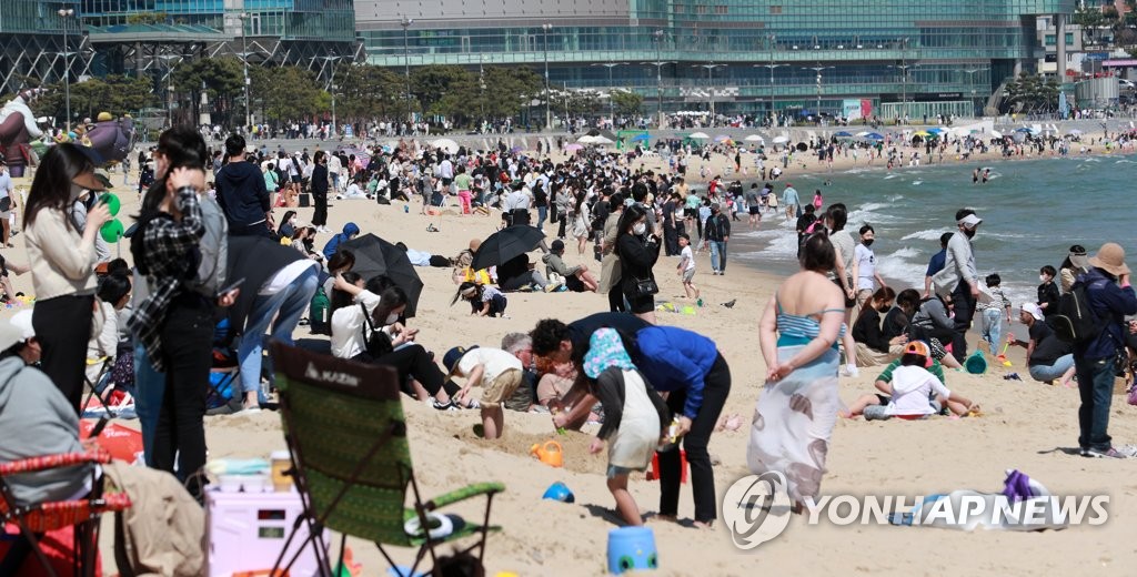 资料图片：5月5日，在釜山海云台海水浴场，孩子们和家人们尽情玩耍。当天是韩国儿童节。 韩联社