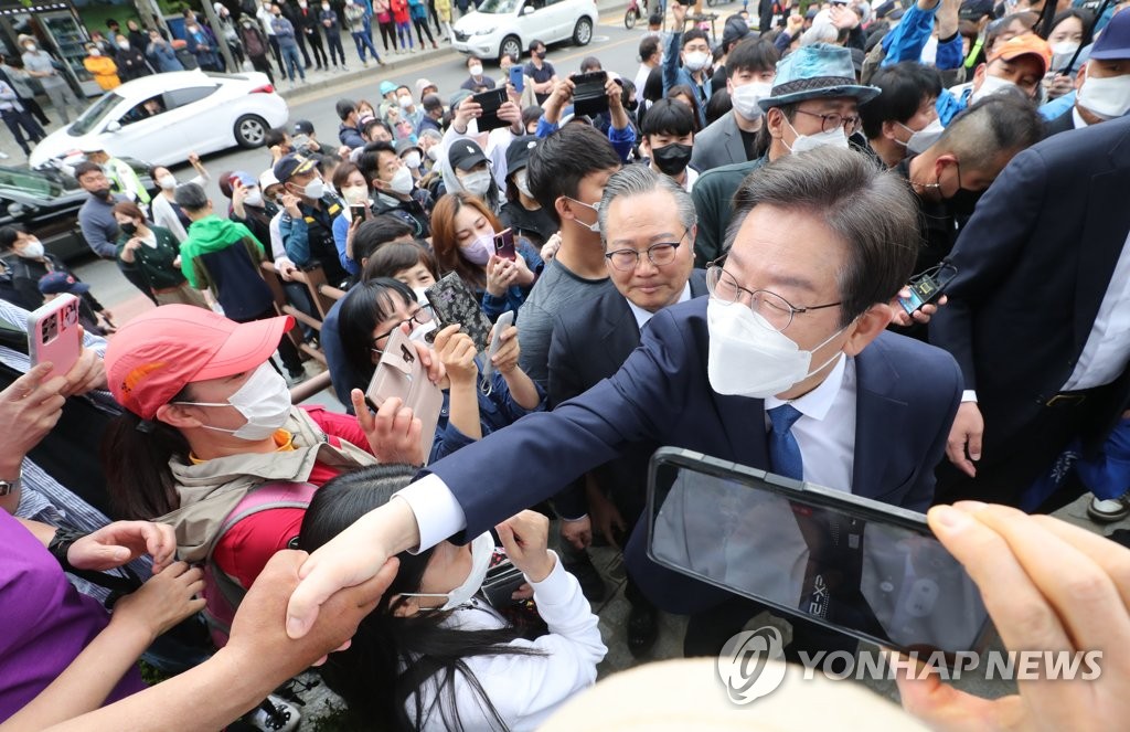 5月8日，在仁川桂阳山的露天舞台，李在明召开记者会宣布参选议员。图为李在明与支持者握手致意。 韩联社/国会摄影记者团