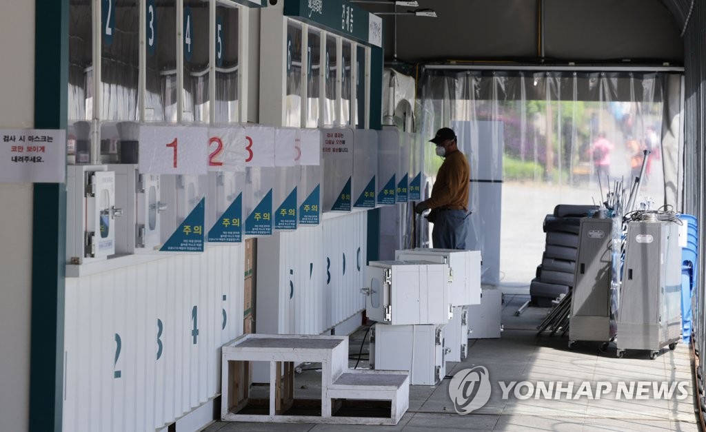 资料图片：5月9日，在设于首尔市西大门区独立门广场的新冠临时筛查诊所，工作人员拆除设施。 韩联社