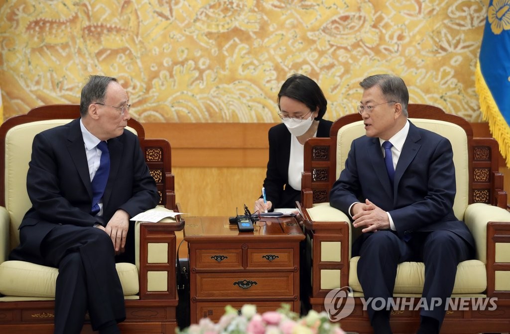 5月9日，在青瓦台主楼，韩国总统文在寅（右）同到访的中国国家副主席王岐山面谈。 韩联社
