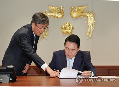 5月10日，在首尔龙山总统府，总统尹锡悦（右）签批国务总理被提名人韩悳洙任命案。左为总统秘书室室长金大棋。 韩联社