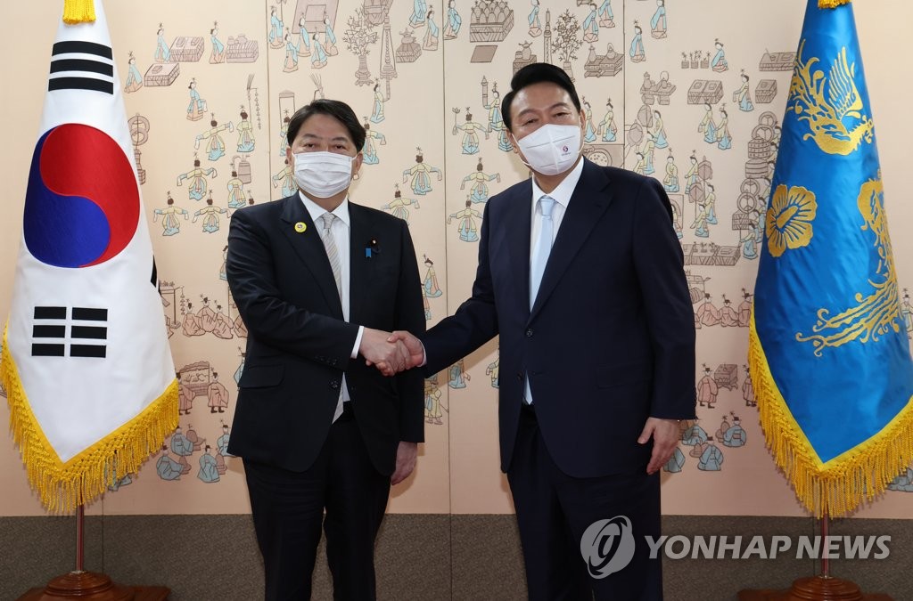 资料图片：5月10日下午，在首尔龙山总统府，韩国总统尹锡悦（右）与日本外务大臣林芳正握手合影。 韩联社