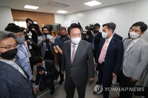 资料图片：5月13日，韩国总统尹锡悦（居中）参观位于首尔龙山总统室大楼内的记者室。 韩联社/总统室摄影记者团