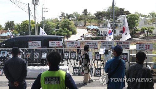 资料图片：5月15日，在位于庆尚南道梁山市平山村的前总统文在寅的私邸前，警察在路旁待命，以维持示威人群秩序并处理突发情况。 韩联社