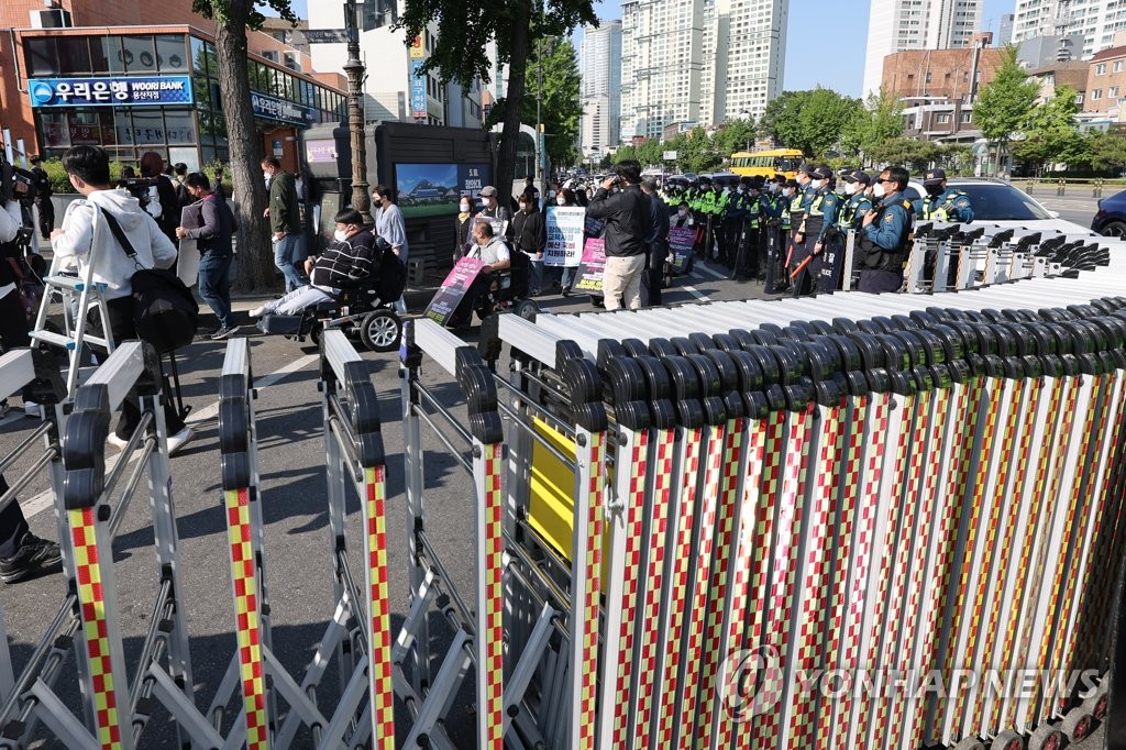资料图片：2022年5月16日，韩国全国废除歧视残障人连带在首尔三角地地铁站附近进行游行，警方设置护栏维护现场秩序。 韩联社