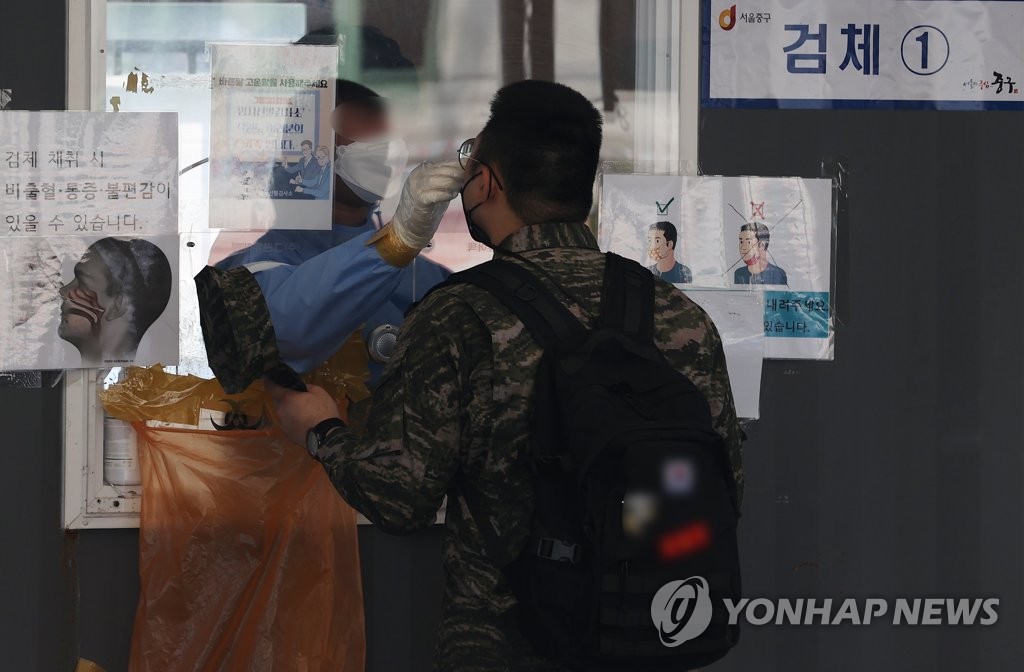 资料图片：5月20日，在设于首尔站的筛查诊所，一名市民正接受新冠检测。 韩联社