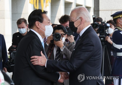 5月21日，在首尔龙山总统府大楼，韩国总统尹锡悦（左）迎接到访的美国总统拜登。 韩联社