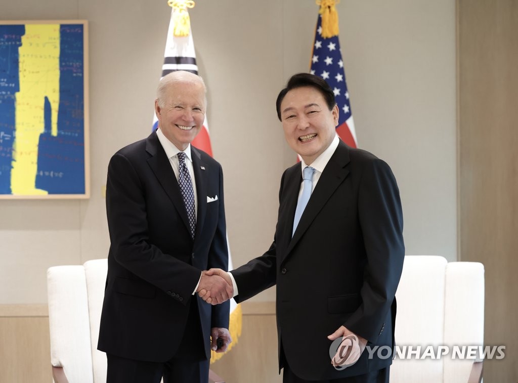5月21日，在首尔龙山总统府，韩国总统尹锡悦（右）与美国总统拜登握手合影。 韩联社