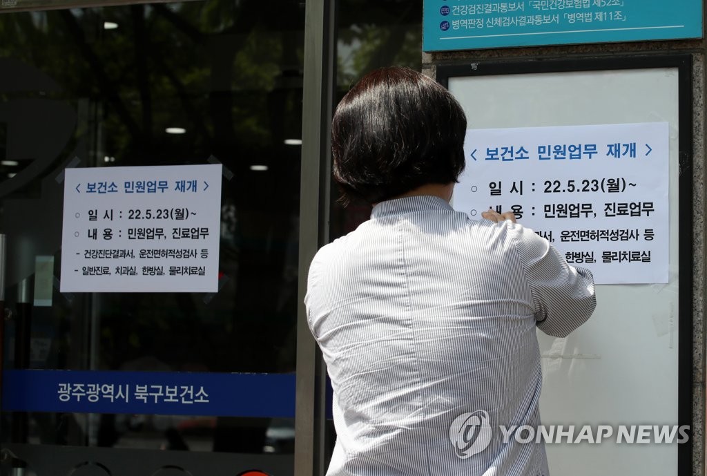 资料图片：5月23日，在光州市北区卫生站，工作人员贴出重启信访及门诊服务的通知。 韩联社