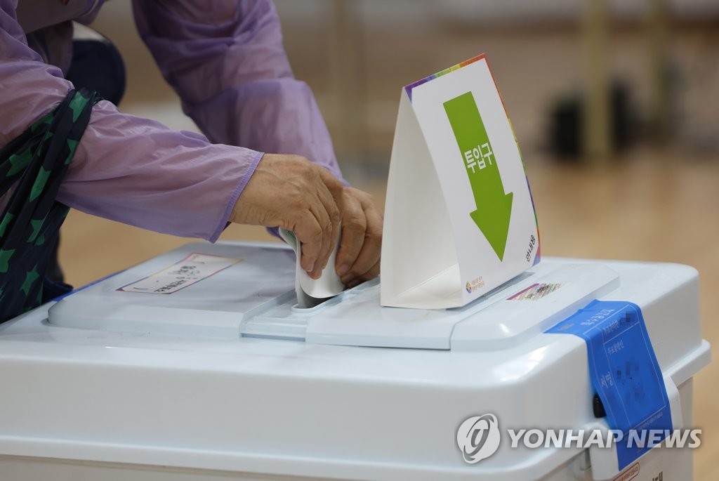5月27日，在首尔中区茶山洞缺席投票点，一选民正在投票。 韩联社
