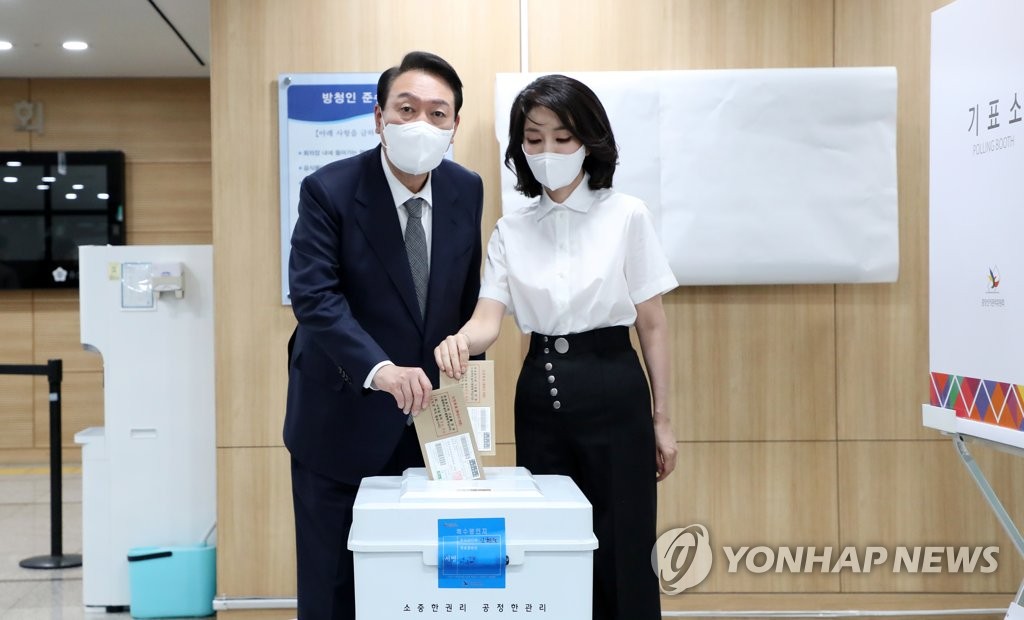 5月27日，在设于首尔市龙山区议会大楼的地方选举缺席投票站，韩国总统尹锡悦（左）和夫人金建希正在投票。 韩联社/总统府通讯摄影记者团