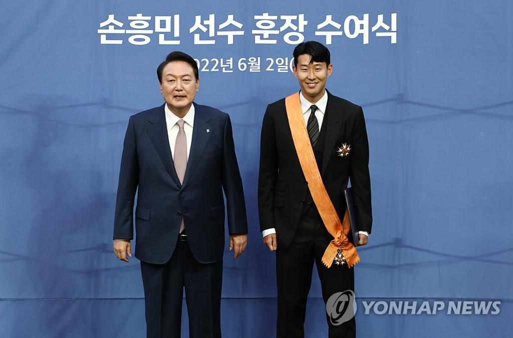 6月2日，韩国总统尹锡悦（左）亲自前往首尔世界杯体育场，向英超首位来自亚洲的金靴奖得主孙兴慜授予韩国最高级别体育勋章“青龙章”。 韩联社