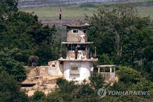 资料图片：6月3日，从京畿道坡州市都罗山瞭望台向北遥望韩朝非军事区西段朝方一侧，可以看到朝军哨所里有一名士兵仰望天空。 韩联社