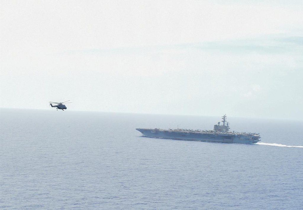 资料图片：韩美两军从6月2日起在日本冲绳东南方向公海上联合实施航母战斗群演习，为期三天。图为美军MH-60直升机准备在“里根”号核动力航母上降落。 韩联社/联参供图（图片严禁转载复制）