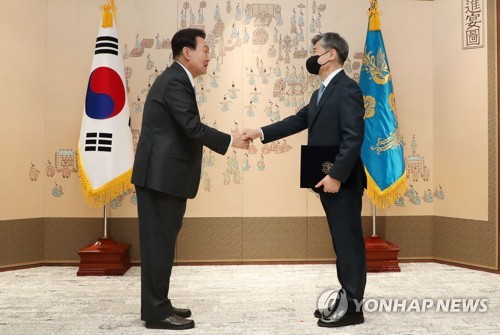 6月10日，在龙山总统办公室，韩国总统尹锡悦（左）向韩国驻美大使赵太庸授予国书后二人握手合影。 韩联社/总统室通讯摄影记者团