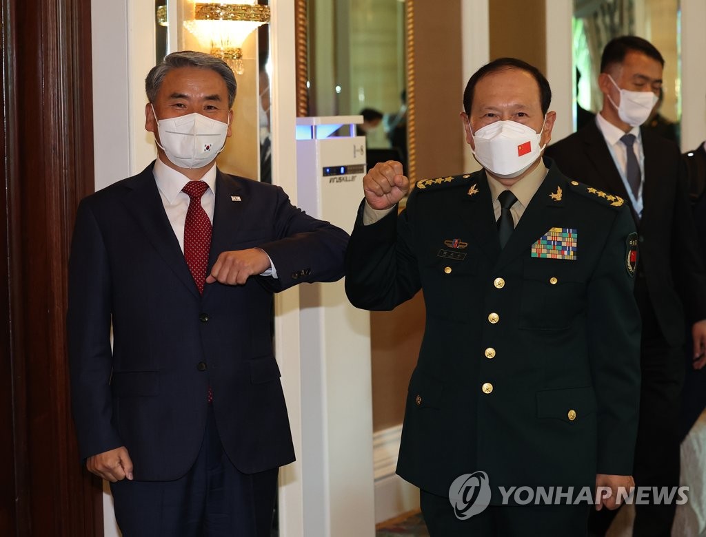资料图片：2022年6月10日，在新加坡香格里拉酒店，韩国国防部长官李钟燮（左）和中国国防部长魏凤和碰肘致意。双方借出席第19届亚洲安全峰会（香格里拉对话会）之机举行会谈。 韩联社