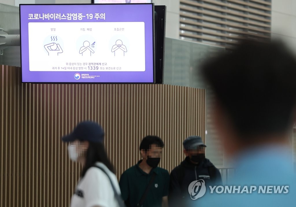 资料图片：机场电视屏正在播放预防新冠病毒的宣传视频。 韩联社
