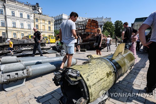 当地时间6月12日，在乌克兰首都基辅的圣米迦勒金顶修道院广场，民众查看散落在街头的俄军导弹残骸。 韩联社 