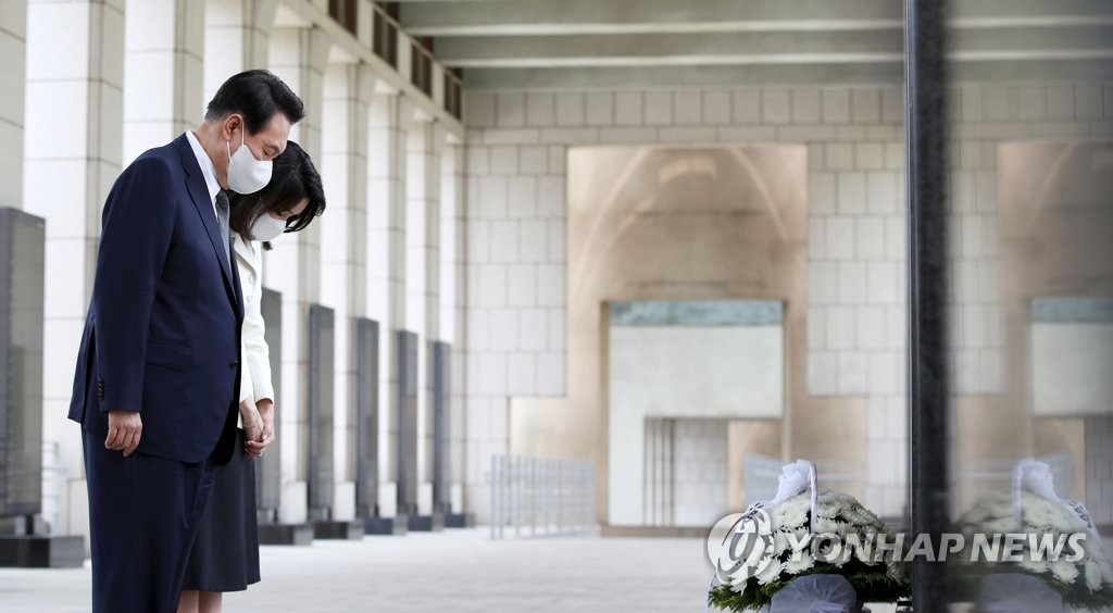 6月17日，在位于首尔龙山区的战争纪念馆，韩国总统尹锡悦和夫人金建希邀请国家有功人士及家属共进午餐。图为尹锡悦夫妇在英雄烈士的铭碑前低头默哀。 韩联社