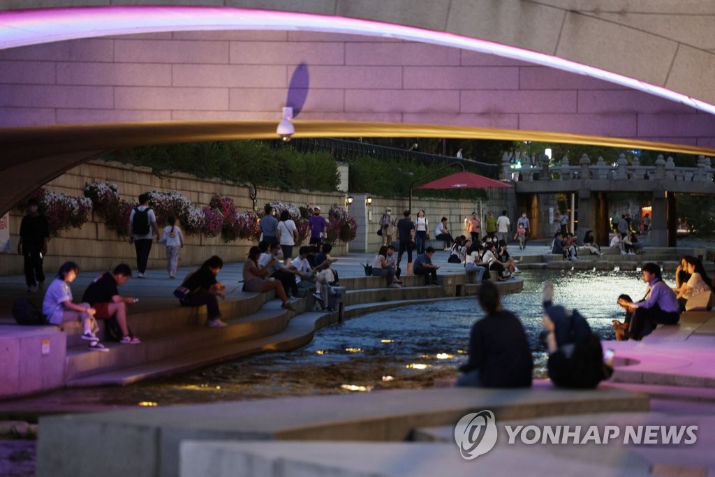 资料图片：首尔市民在钟路区的清溪川乘凉。 韩联社