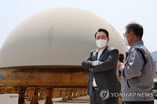 6月22日，在位于庆尚南道昌原市的斗山能源（Doosan Enerbility）工厂，韩国总统尹锡悦（左）视察用于铸造新韩蔚核电站3、4号机组反应堆及蒸汽发生器的金属材料库。 韩联社