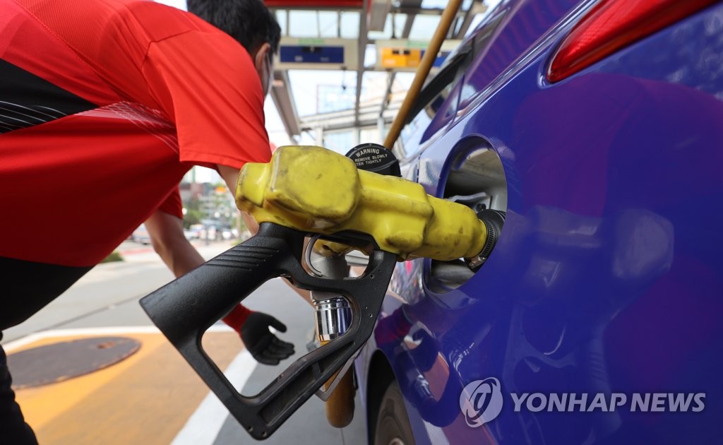 资料图片：6月22日，在首尔一家加油站，员工正在加油。 韩联社