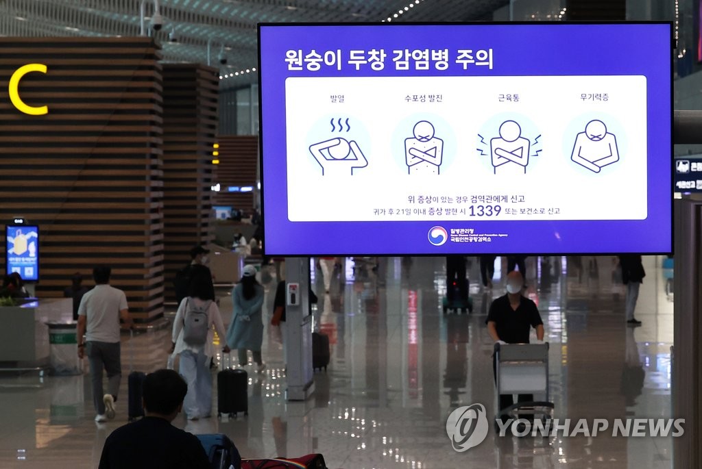 资料图片：6月23日，设置在仁川国际机场第二航站楼的大型屏幕显示猴痘防控注意事项。 韩联社