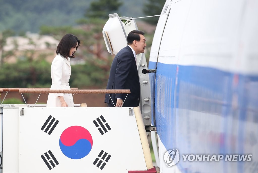 6月27日，在位于京畿道城南市的首尔机场，韩国总统尹锡悦（右）和夫人金建希正在踏上总统专机空军一号。尹锡悦为出席29日至30日举行的北约（NATO）首脑会议而启程赴西班牙。 韩联社