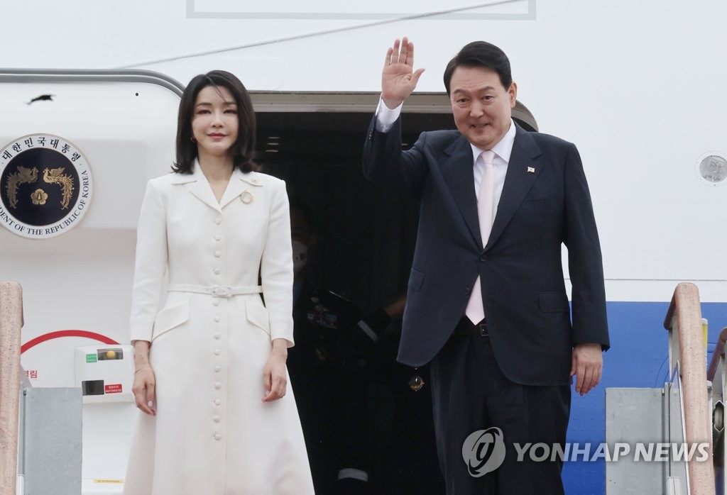 6月27日，在位于京畿道城南市的首尔机场，韩国总统尹锡悦（右）和夫人金建希踏上总统专机空军一号，并向前来送行的人群挥手致意。 韩联社