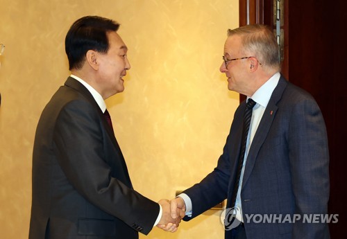 当地时间6月28日，在西班牙马德里，韩国总统尹锡悦（左）同澳大利亚总理安东尼·阿尔巴尼斯握手。尹锡悦此次为出席北大西洋公约组织（北约）首脑会议而访问西班牙。 韩联社