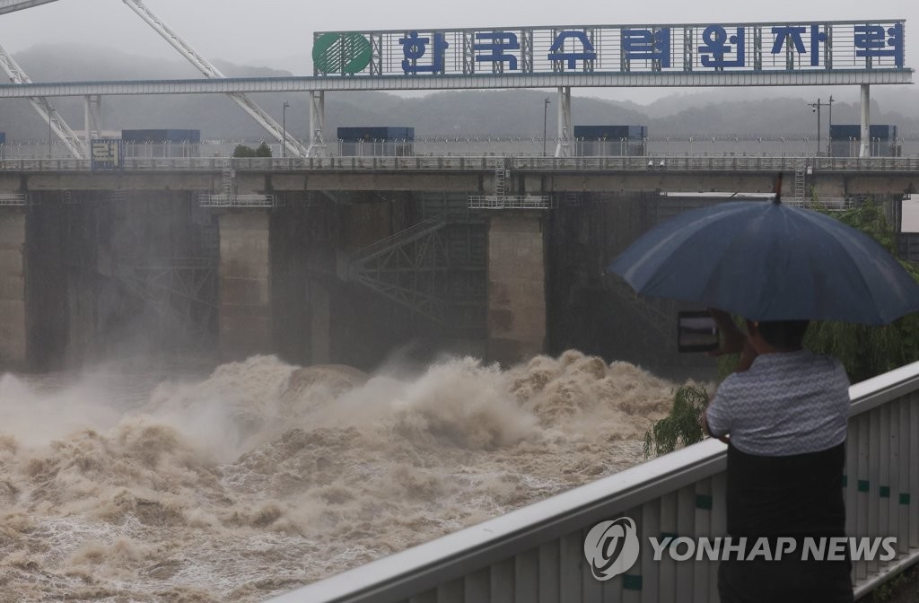 6月30，在京畿道河南市八堂水坝，市民欣赏一泄千里的场面。 韩联社