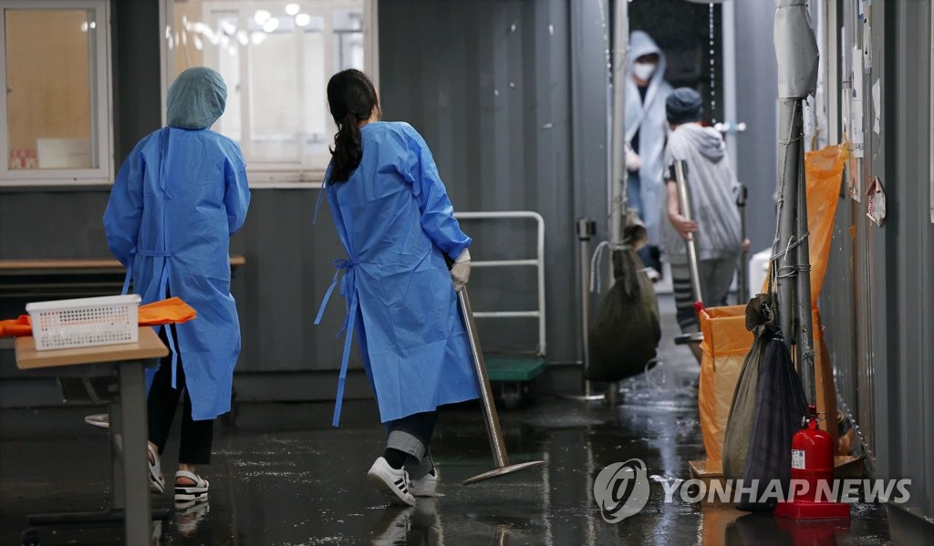 资料图片：6月30日，在设于首尔火车站的临时筛查诊所，中区有关人士和医务人员正在拆除设施。 韩联社