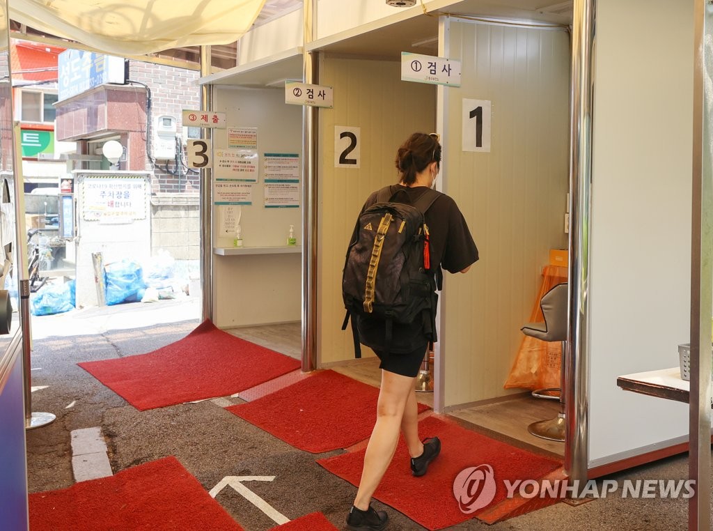 资料图片：7月3日，在位于首尔市区的一处新冠筛查诊所，一名市民准备接受病毒检测。 韩联社