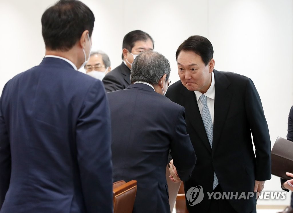 7月4日，在首尔市龙山总统府，韩国总统尹锡悦（右一）接见到访的日本经济团体联合会代表团。图为尹锡悦与日本经济团体联合会会长十仓雅和握手致意。 韩联社