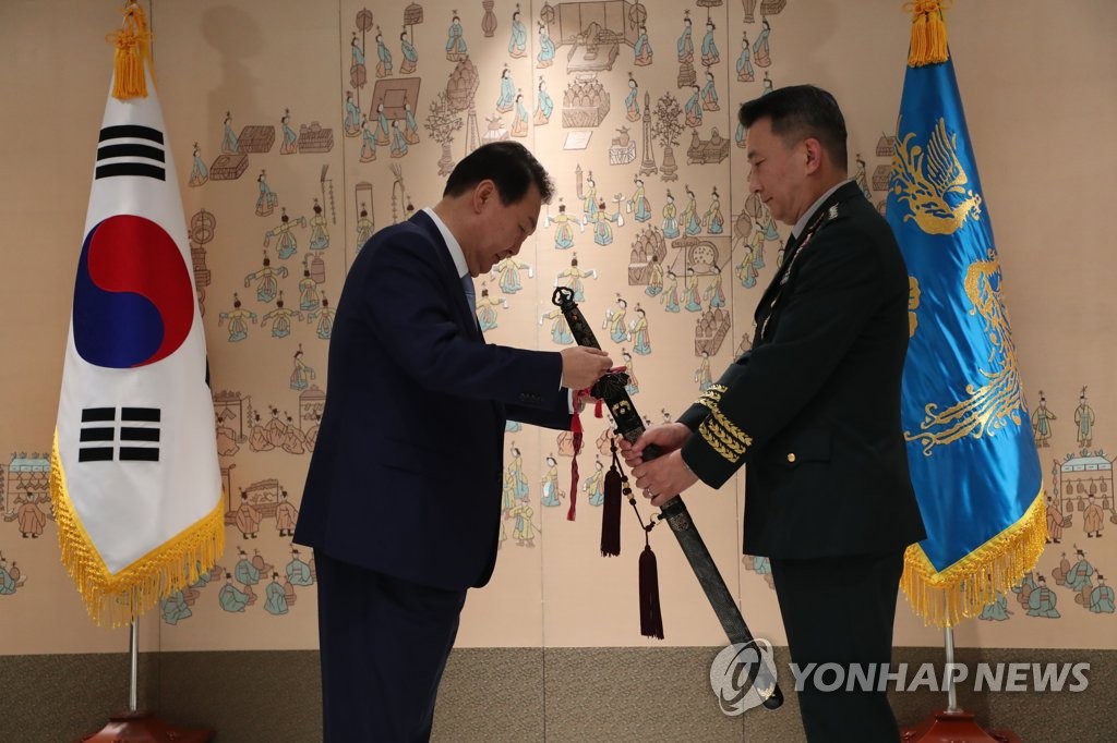7月5日，在首尔龙山总统办公楼，韩国总统尹锡悦（左）向新任联合参谋本部议长金承谦授予三精剑。 韩联社/总统室通讯摄影记者团