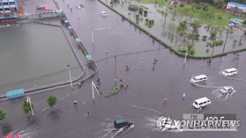 据朝鲜中央电视台报道，朝鲜平安北道新义州市7月7日遭遇今年最大暴雨袭击，从当天零时至下午5时的降雨量达到132.5毫米。图为路变河、车变船的新义州市区的道路严重积水。 韩联社/朝鲜央视画面（图片仅限韩国国内使用，严禁转载复制）