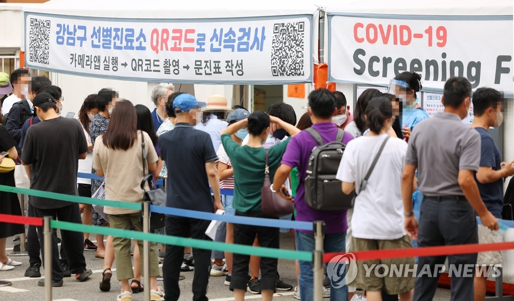 资料图片：7月12日，在设于首尔江南区卫生站的新冠筛查诊所，市民们排队待检。 韩联社