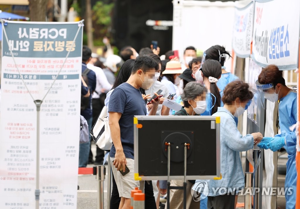 资料图片：7月12日上午，在首尔江南区卫生站的新冠筛查诊所，众多市民等待接受病毒检测。 韩联社