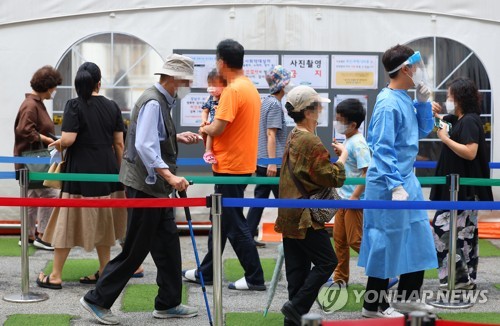 资料图片：新冠疫情抬头，采样队伍变长。 韩联社