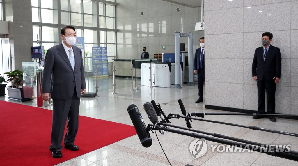 7月20日，在首尔龙山总统室，总统尹锡悦（左）在出勤途中的简约记者会上回答记者提问。 韩联社/总统府通讯摄影记者团