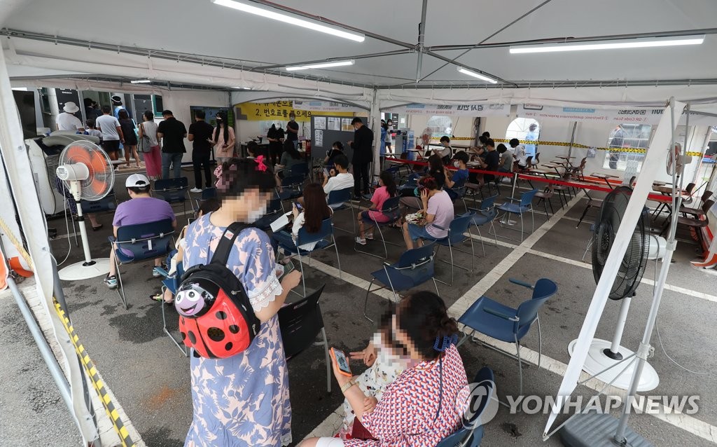 7月22日，在设于首尔市江南区卫生站的新冠临时筛查诊所，市民排长队待检。 韩联社