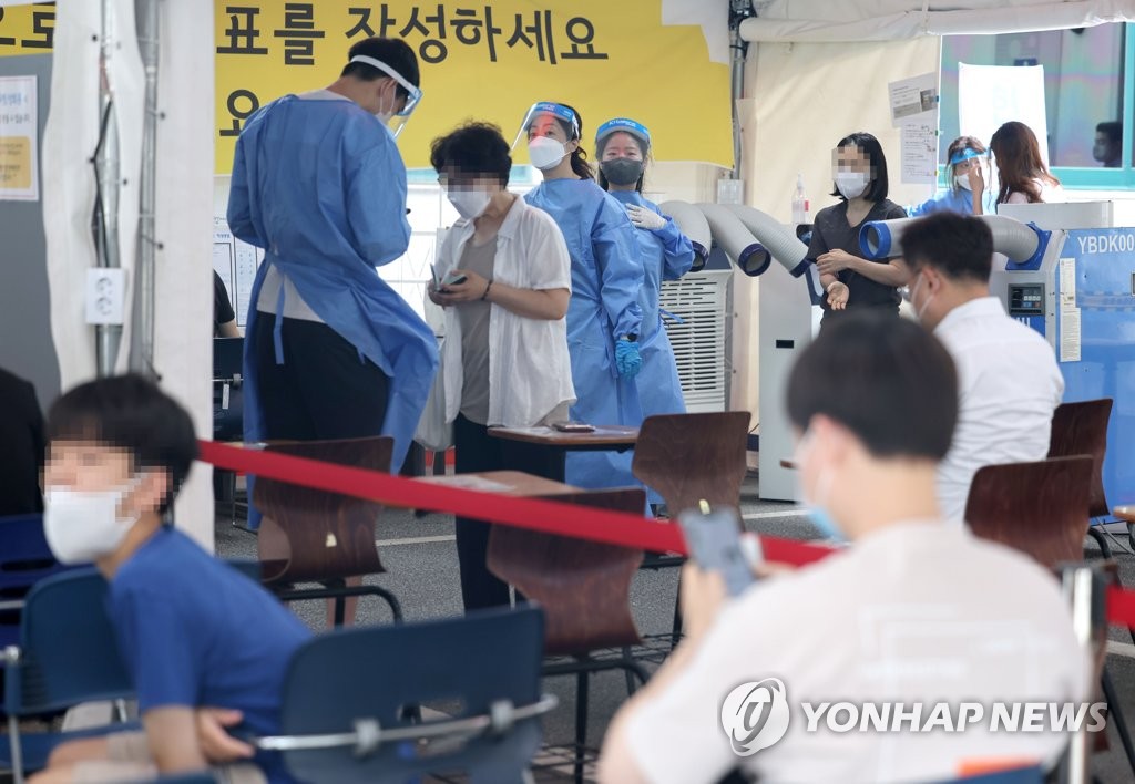 7月22日，在设于首尔市江南区卫生站的新冠临时筛查诊所，医务人员因核酸检测而繁忙。 韩联社