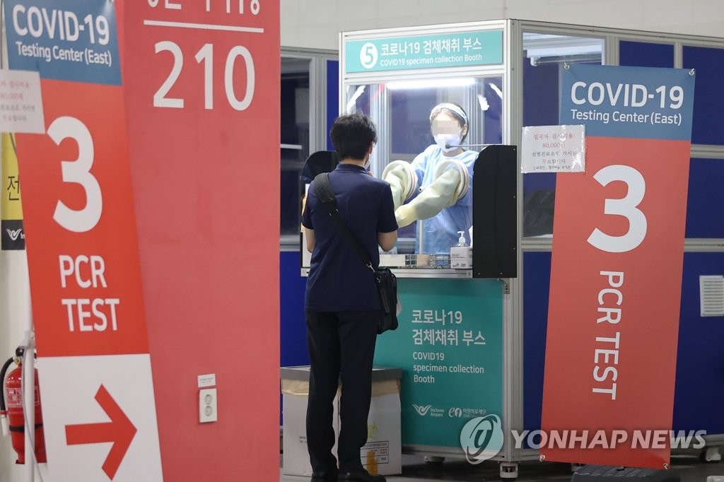 资料图片：7月24日，在仁川国际机场第二航站楼，医务人员正在为入境人员进行核酸检测。 韩联社