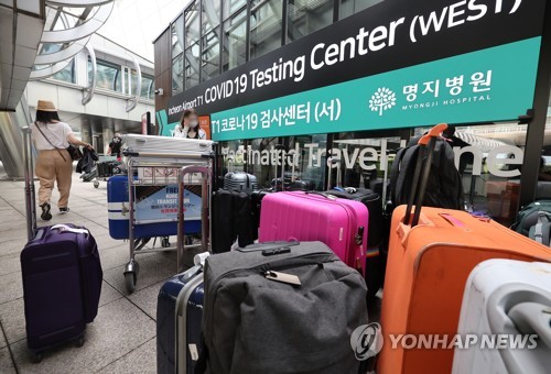 资料图片：7月26日，在仁川国际机场第一航站楼，入境旅客专用新冠检测中心前堆满了行李箱。 韩联社