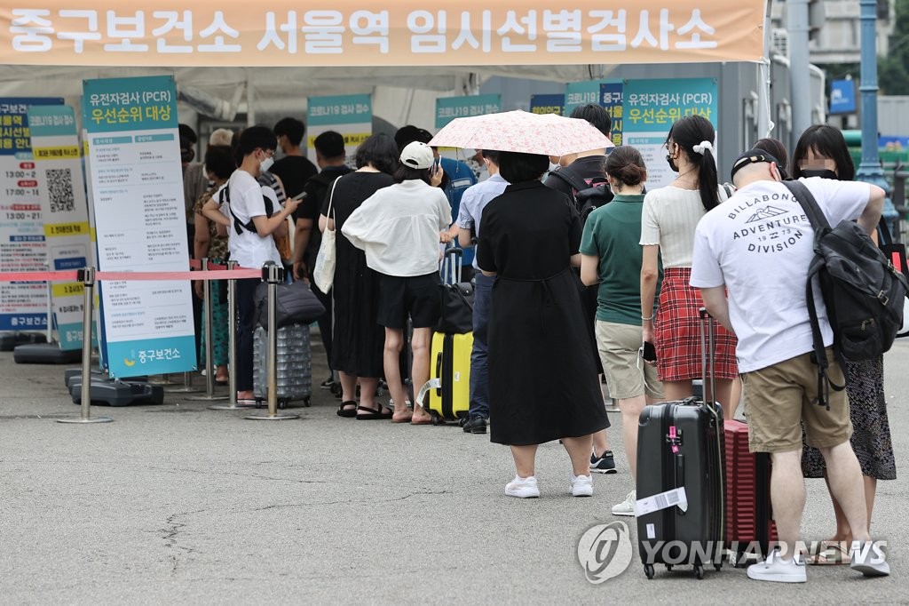 资料图片：8月2日，在位于首尔中区的首尔站筛查诊所，市民们排队待检。 韩联社