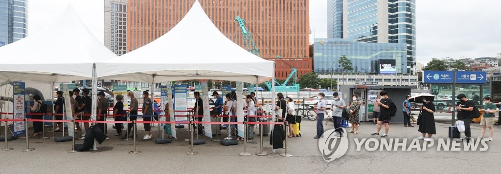 资料图片：8月2日，在设于首尔站广场的新冠临时筛查诊所，市民排队待检。 韩联社